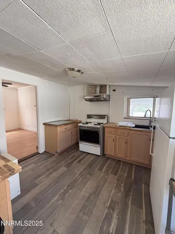 a large kitchen with stainless steel appliances granite countertop a stove a sink dishwasher and a refrigerator