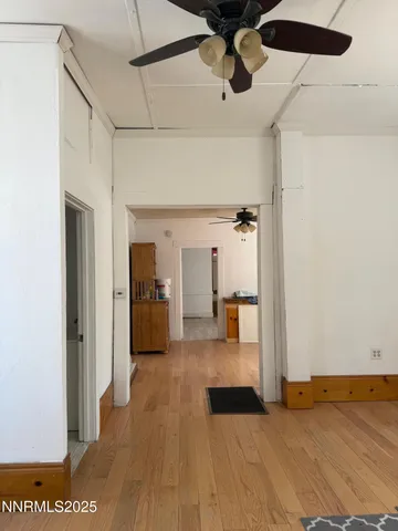 a view of a hallway with wooden floor and closet