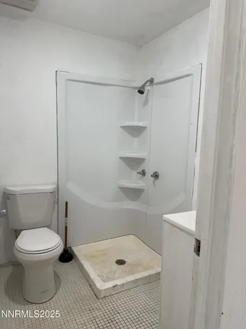 a bathroom with a toilet and a shower