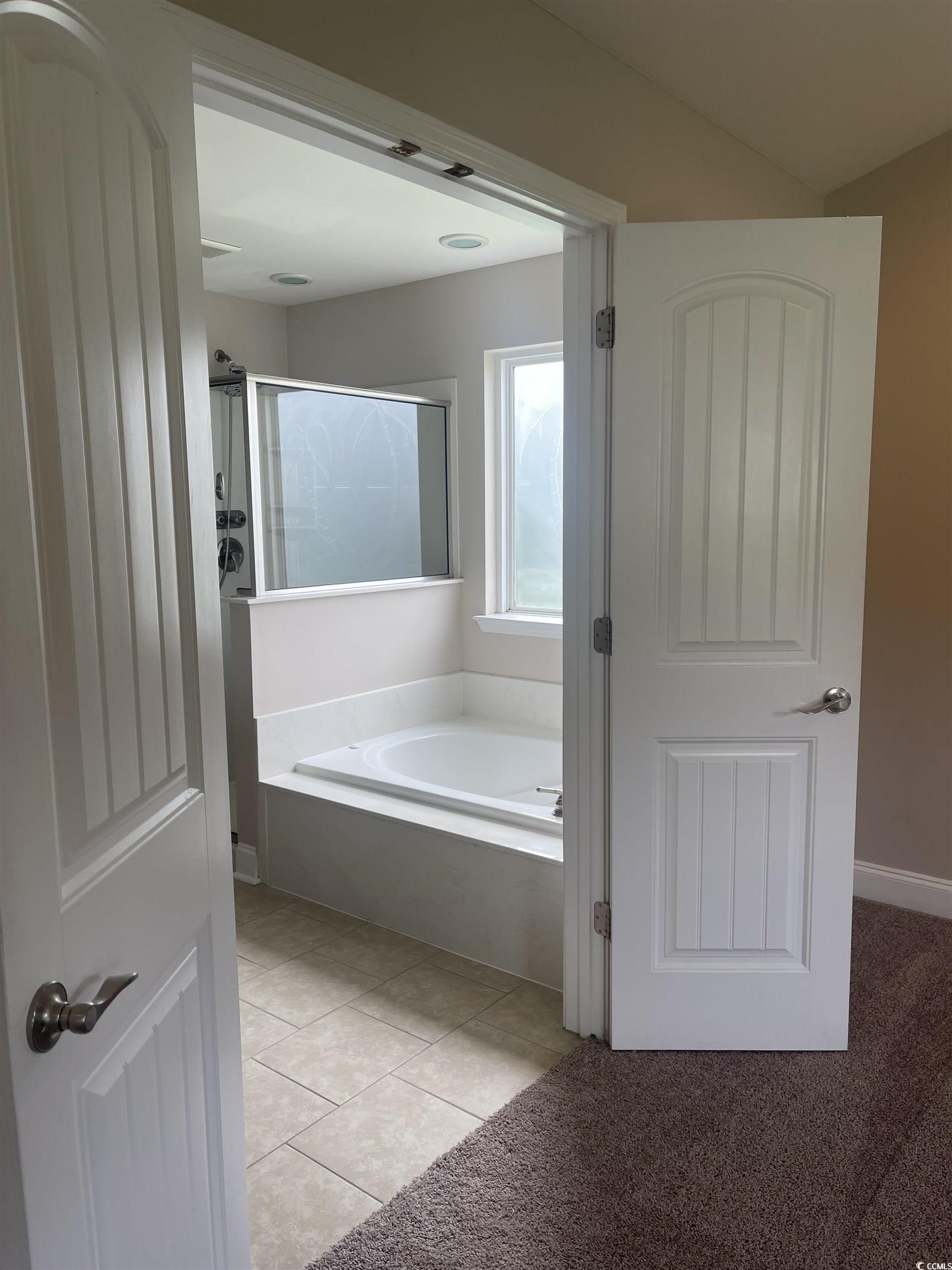 128 Cloey Road Myrtle Beach, SC 29579 - Photo 2 of 22 Bathroom featuring a garden tub, light tile patterned floors, and a shower stall