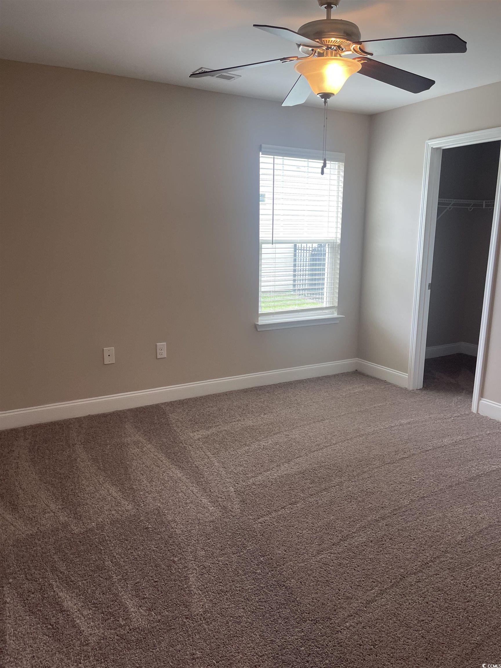 128 Cloey Road Myrtle Beach, SC 29579 - Photo 6 of 22 Guest bedroom featuring light carpet, a walk in closet, and a ceiling fan