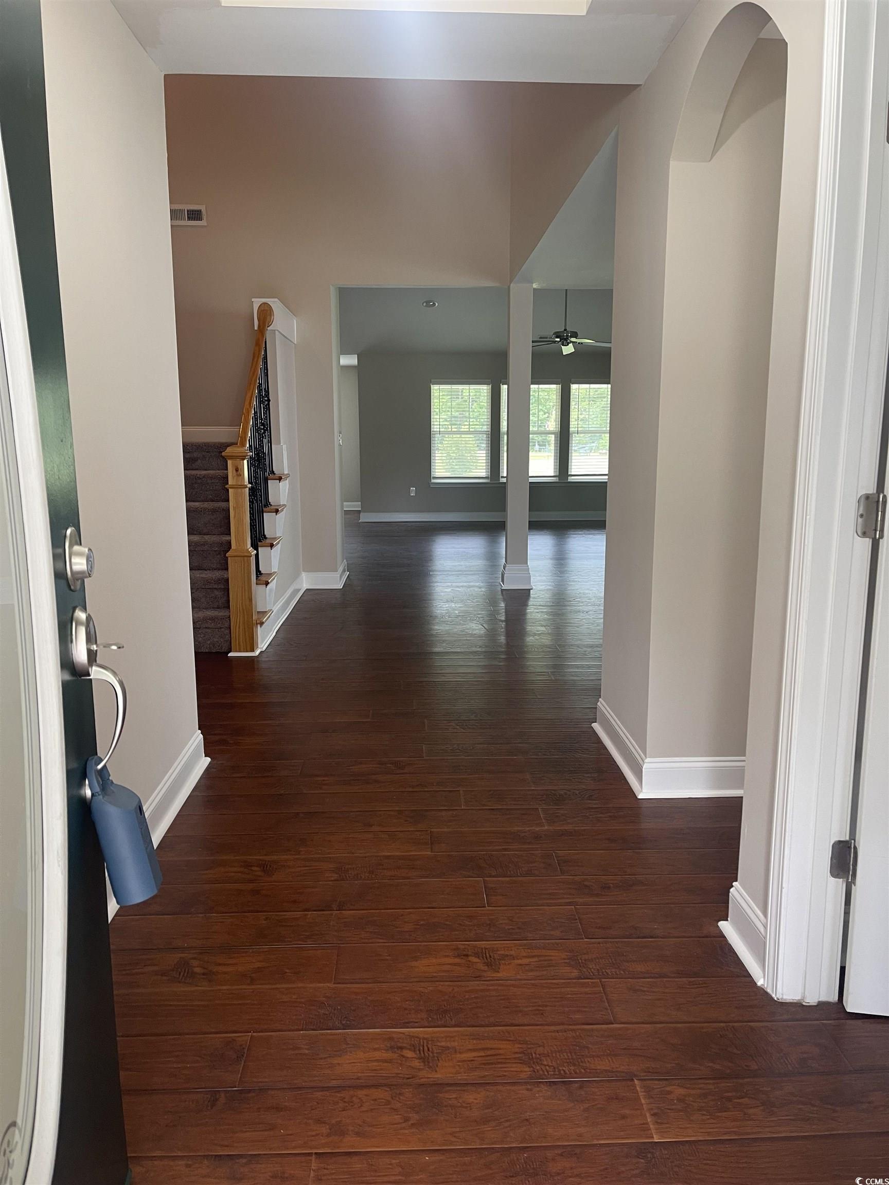 128 Cloey Road Myrtle Beach, SC 29579 - Photo 10 of 22 Foyer featuring stairway, dark wood-style floors, and arched walkways