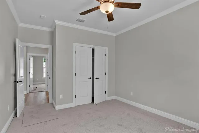 an empty room with windows and fan