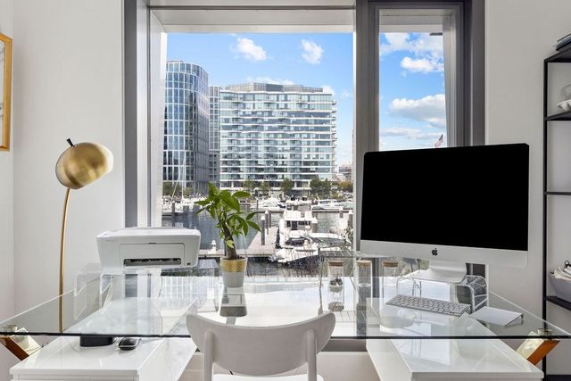 a living room with furniture a flat screen tv and a floor to ceiling window