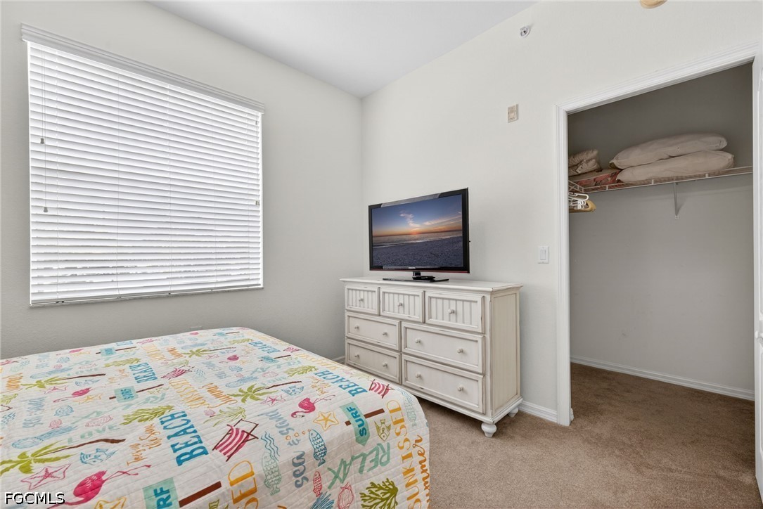 8251 Pathfinder Loop, Unit 621 Fort Myers, FL 33919 - Photo 20 of 30 a bedroom with a bed and flat screen tv