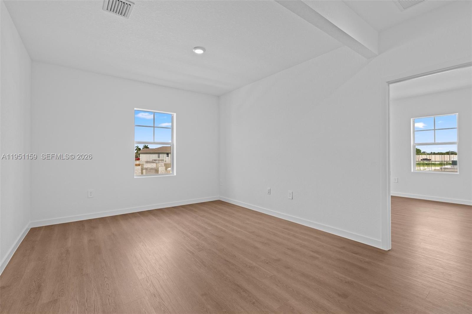 13355 Southwest 272nd Lane Homestead, FL 33032 - Photo 21 of 35 an empty room with wooden floor and windows