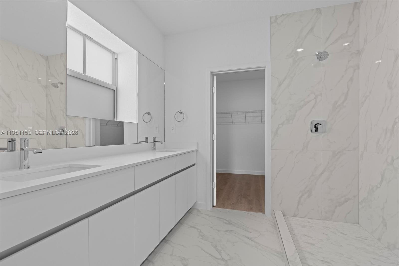 13355 Southwest 272nd Lane Homestead, FL 33032 - Photo 26 of 35 a bathroom with a double vanity sink a mirror and a bathtub