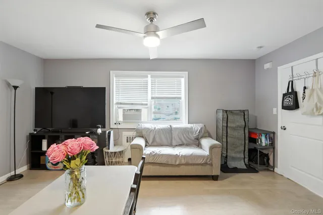 a bedroom with furniture a flat screen tv and a window