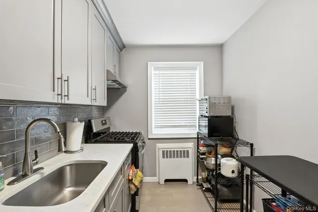 a kitchen with a sink cabinets and a stove top oven