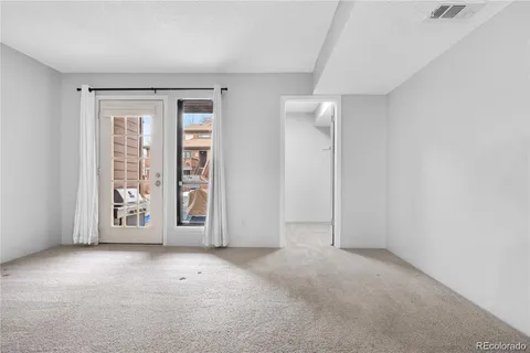 an empty room with entrance and windows