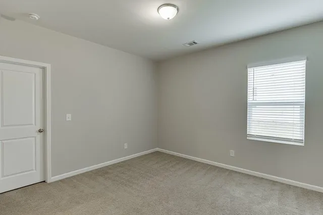 an empty room with closet and a window
