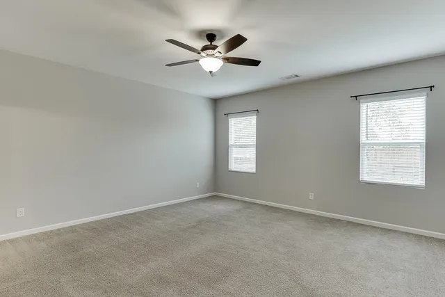 a view of a livingroom with a ceiling fan and window
