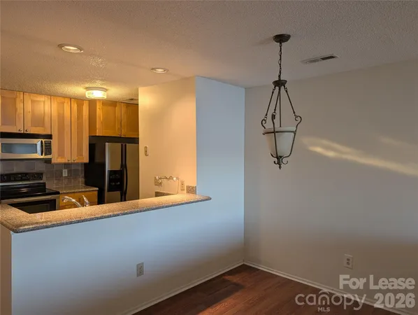 a kitchen with a refrigerator and a stove top oven