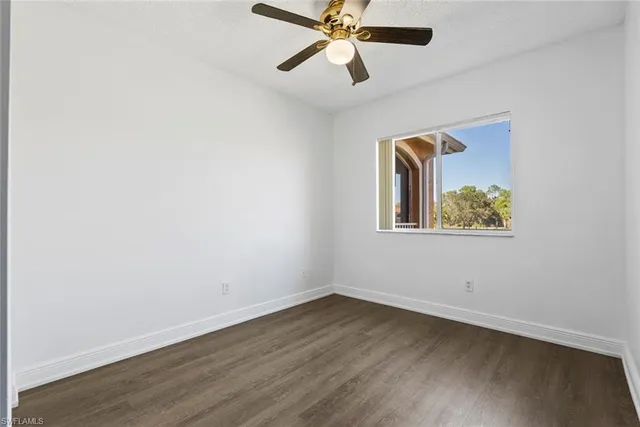 a view of a room with wooden floor and a ceiling fan
