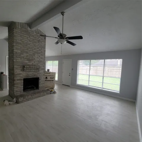 a view of an empty room with a fireplace and a window