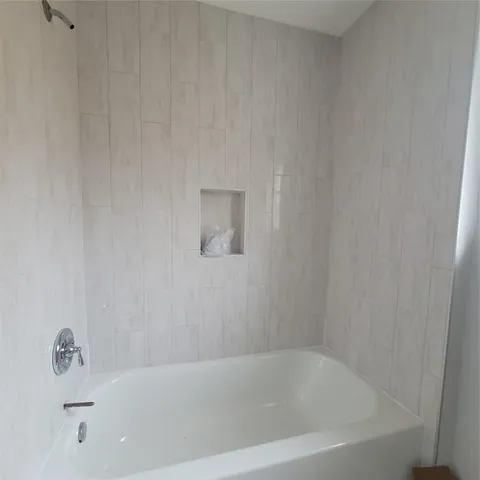 a white bath tub sitting next to a white sink and vanity