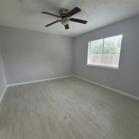 an empty room with a window and a fan