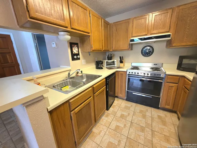 a kitchen with a stove sink and cabinets