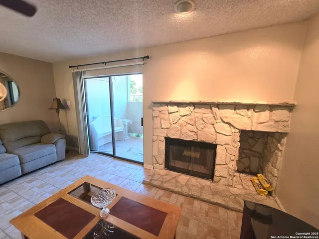 a living room with furniture a fireplace and a flat screen tv