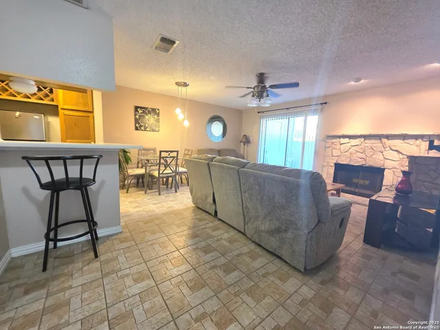 a living room with couches a dining table and chairs with a large window