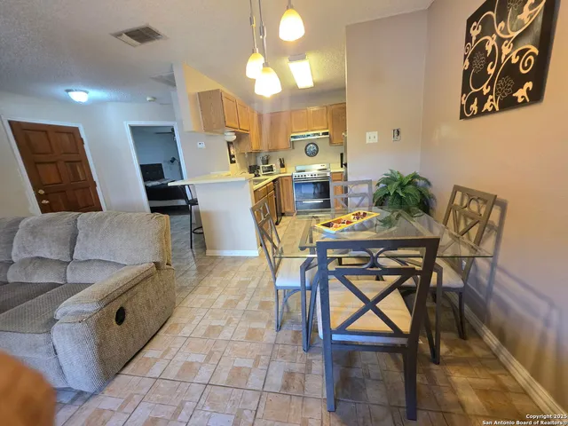 a view of a dining room with furniture and a chandelier