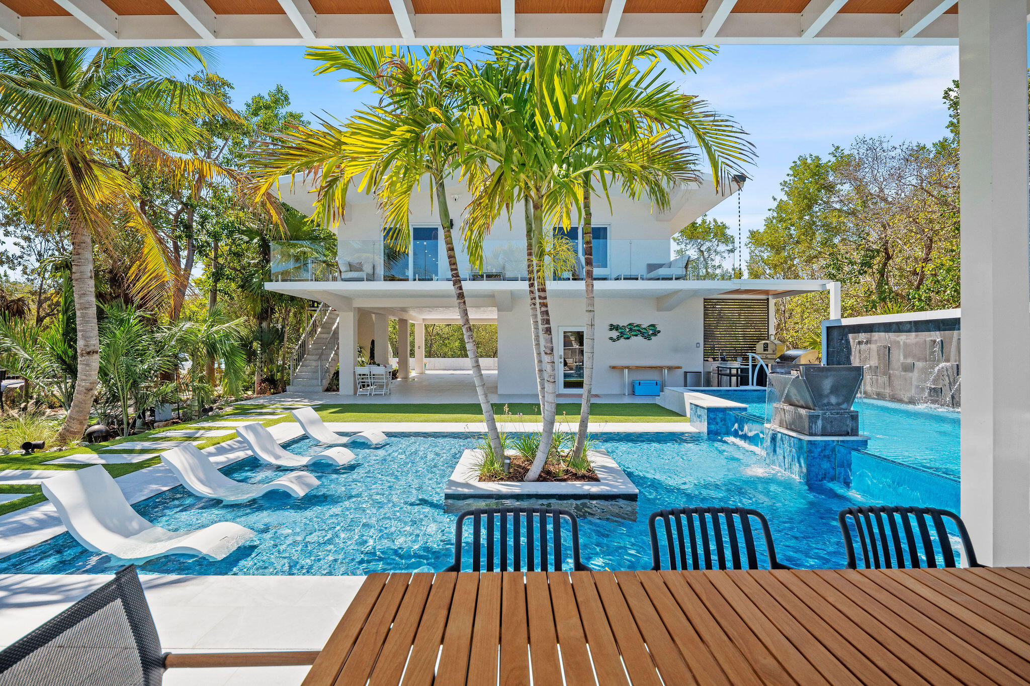 974 Shaw Drive Key Largo, FL 33037 - Photo 45 of 84 a view of a patio with table and chairs potted plants with wooden floor and fence