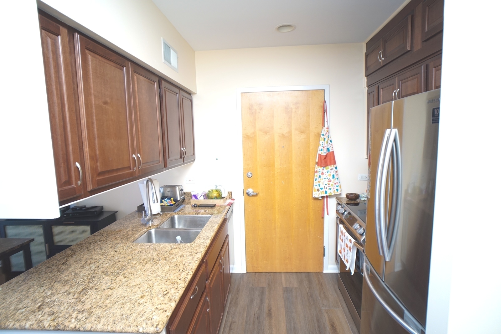 1222 Chicago Avenue, Unit 705 Evanston, IL 60202 - Photo 20 of 33 a kitchen with a refrigerator a sink and wooden floor