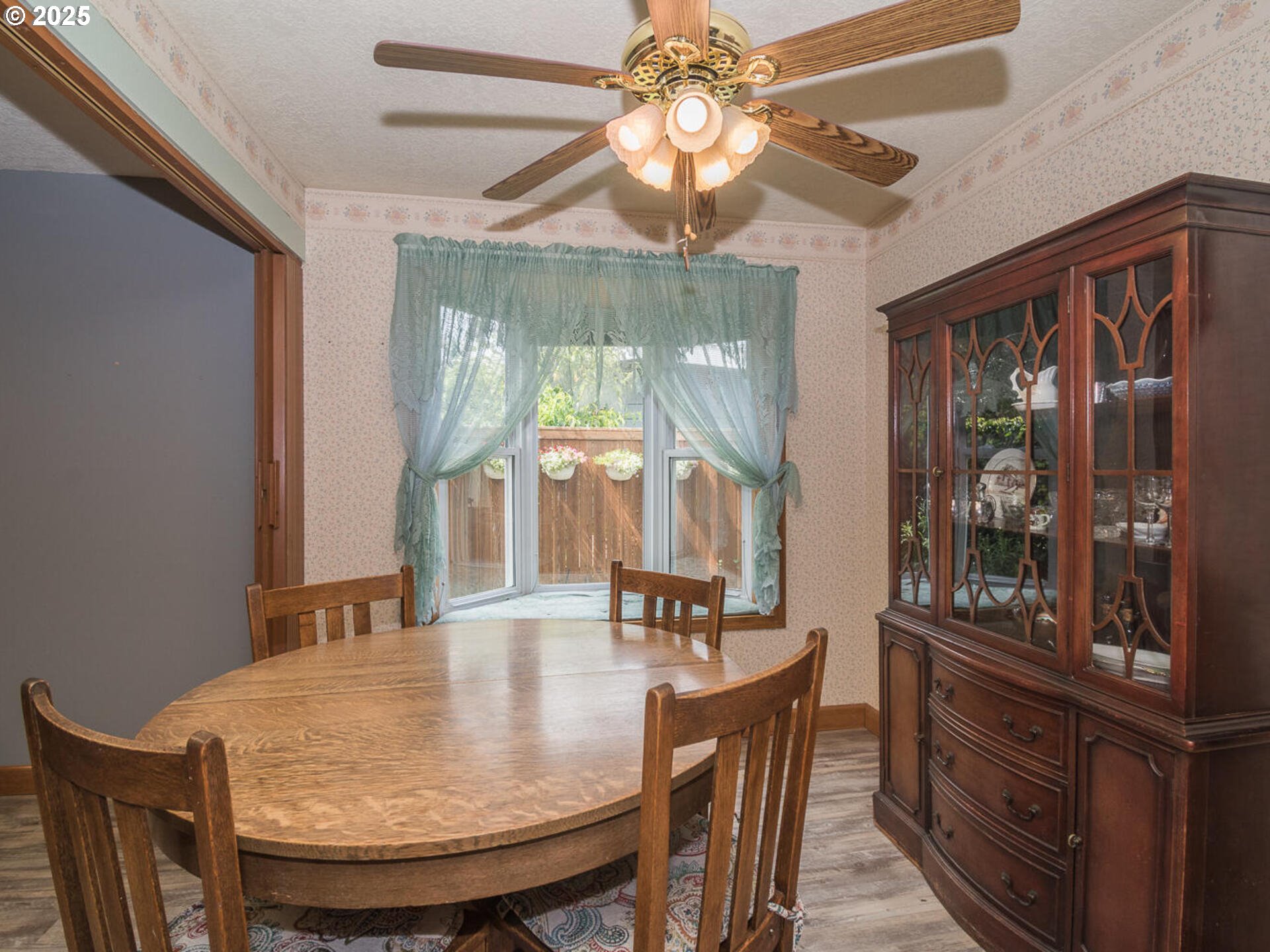 19838 Northeast Wasco Street Portland, OR 97230 - Photo 10 of 42 a dining room with wooden floor a chandelier fan a wooden table and chairs