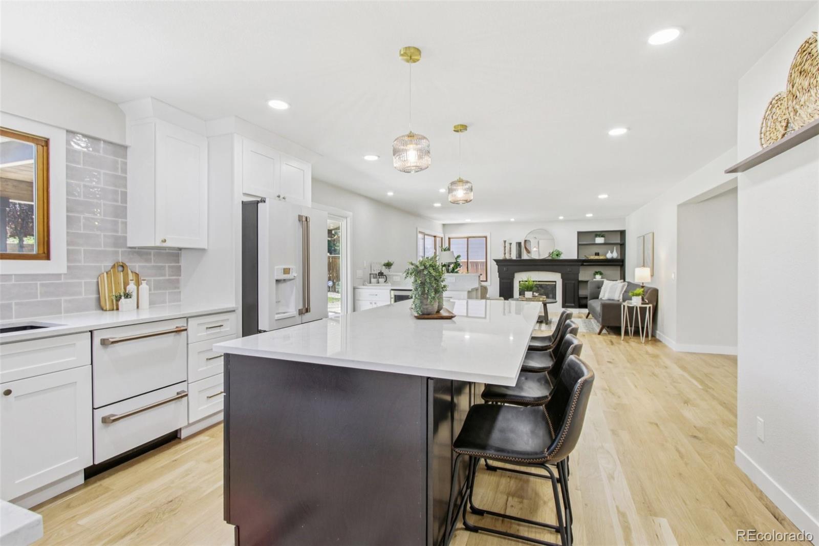 9810 Venneford Ranch Road Highlands Ranch, CO 80126 - Photo 11 of 50 a large kitchen with kitchen island a large counter top space a sink stainless steel appliances and cabinets