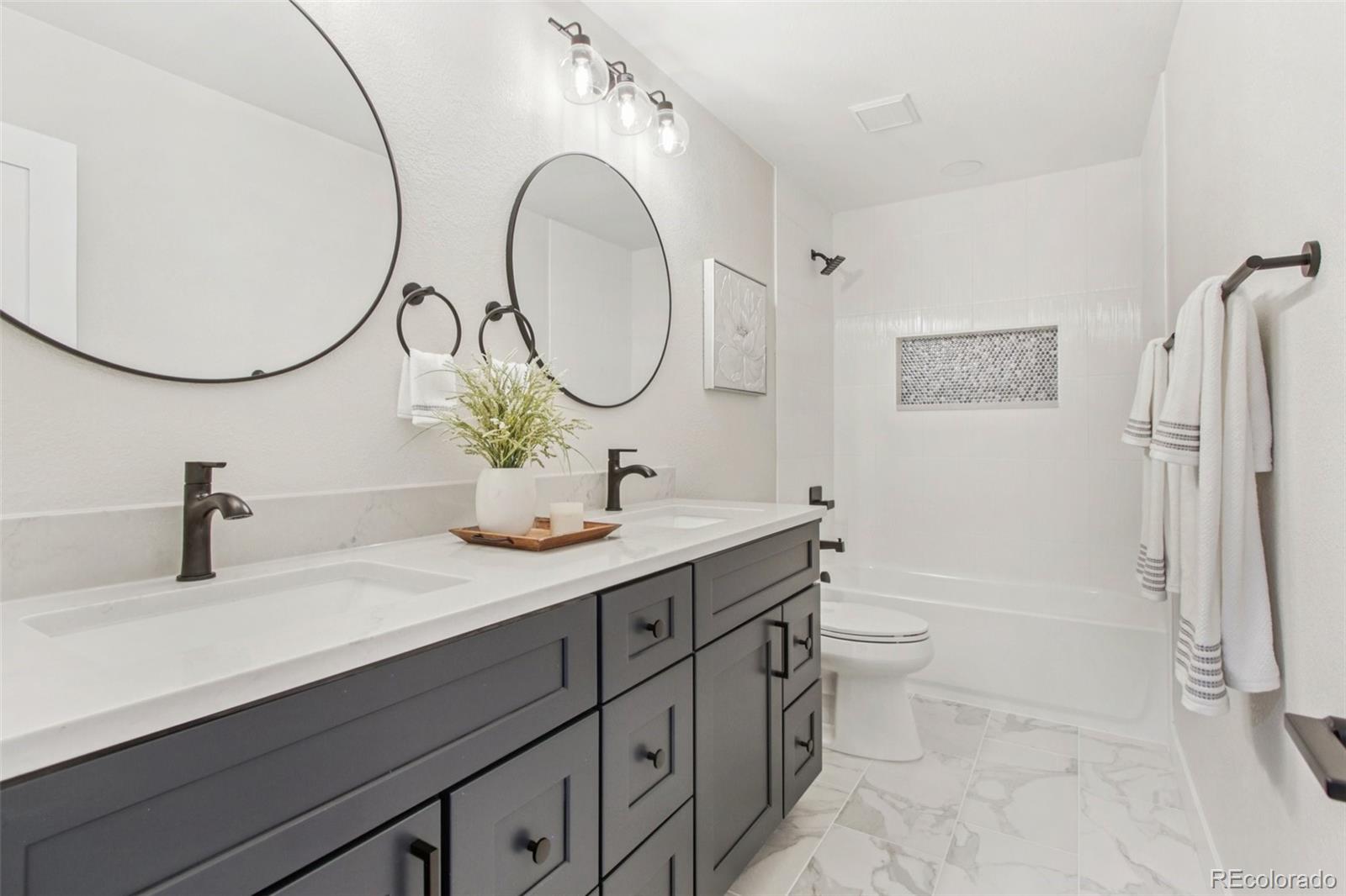 9810 Venneford Ranch Road Highlands Ranch, CO 80126 - Photo 28 of 50 a bathroom with a sink a toilet and a mirror