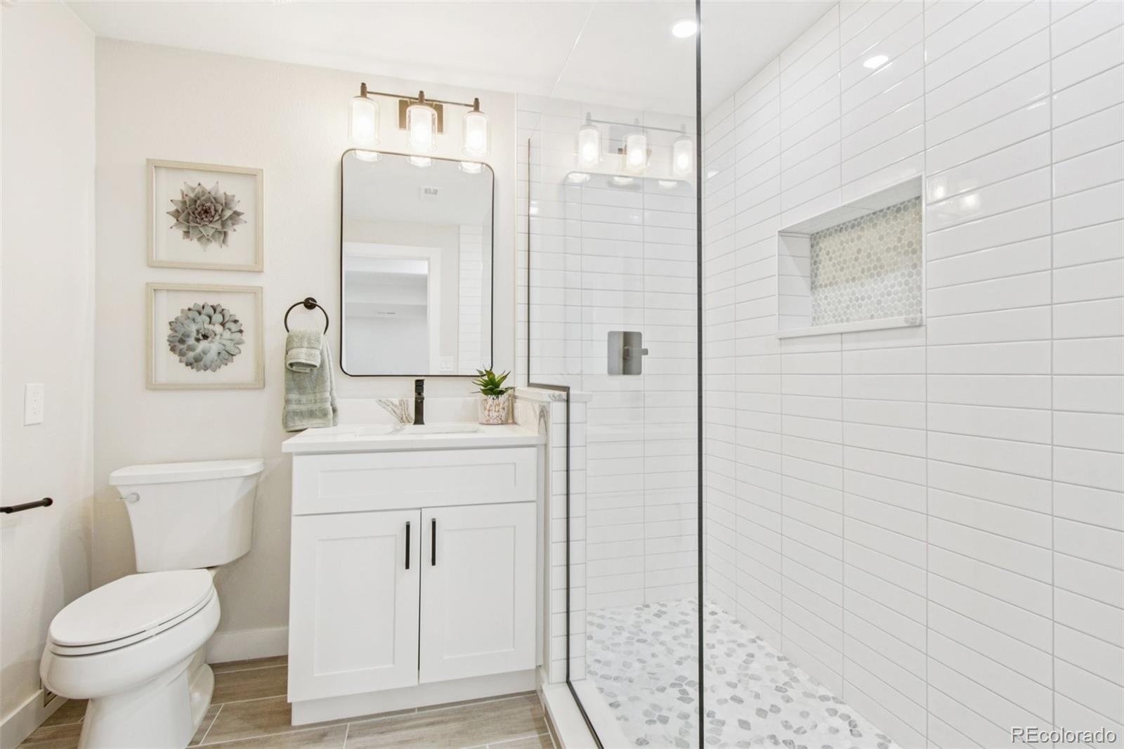 9810 Venneford Ranch Road Highlands Ranch, CO 80126 - Photo 35 of 50 a bathroom with a toilet sink and a mirror