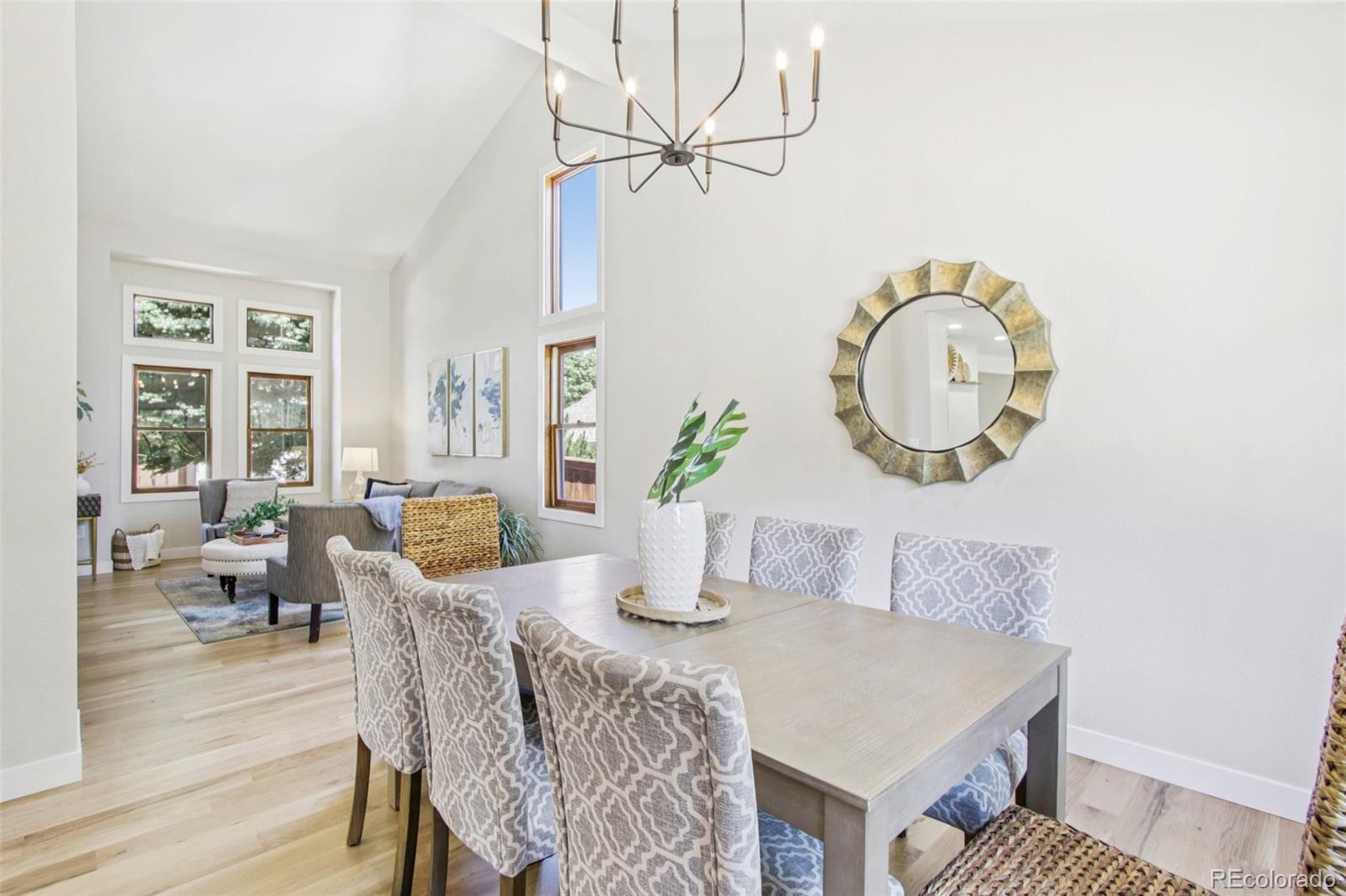 9810 Venneford Ranch Road Highlands Ranch, CO 80126 - Photo 7 of 50 a dining room with wooden floor a chandelier a wooden table and chairs
