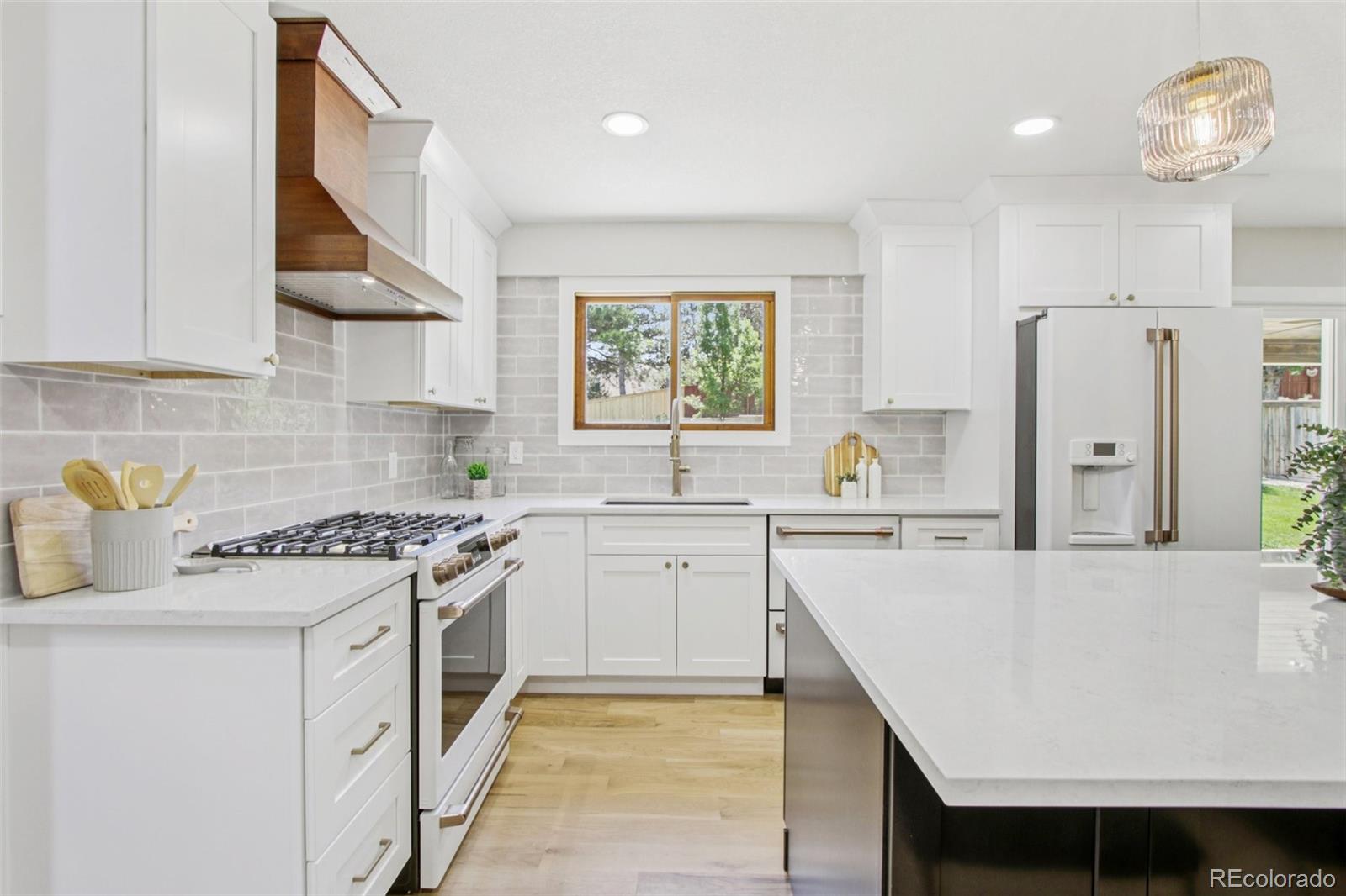 9810 Venneford Ranch Road Highlands Ranch, CO 80126 - Photo 10 of 50 a kitchen with a stove a sink and a refrigerator