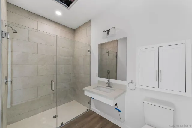 a bathroom with a shower sink and mirror