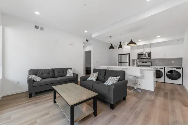 a living room with furniture and kitchen view