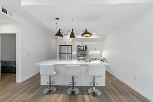 a living room with table chairs and wooden floor