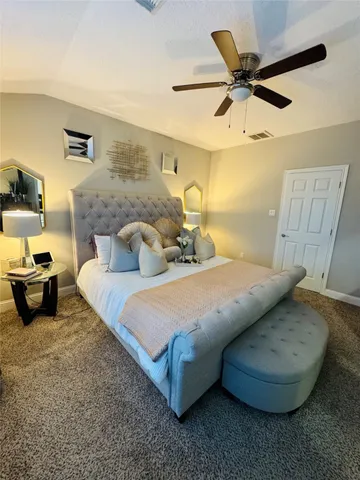 a bedroom with a bed and a ceiling fan