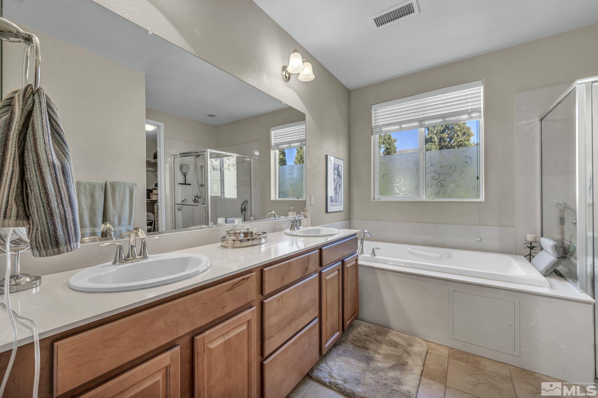 1479 Snow Summit Drive Reno, NV 89523 - Photo 15 of 40 a bathroom with a sink double vanity granite tub shower and a mirror