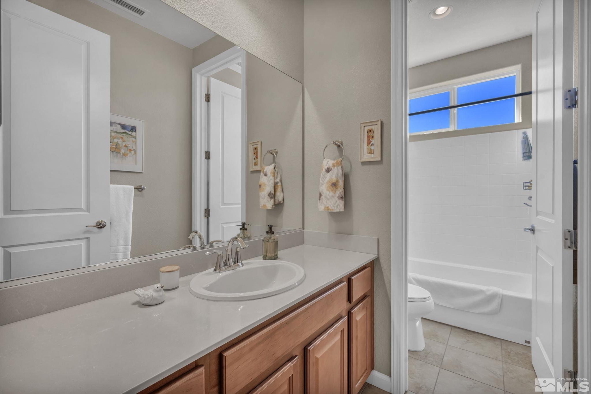 1479 Snow Summit Drive Reno, NV 89523 - Photo 20 of 40 a bathroom with a granite countertop sink and a mirror