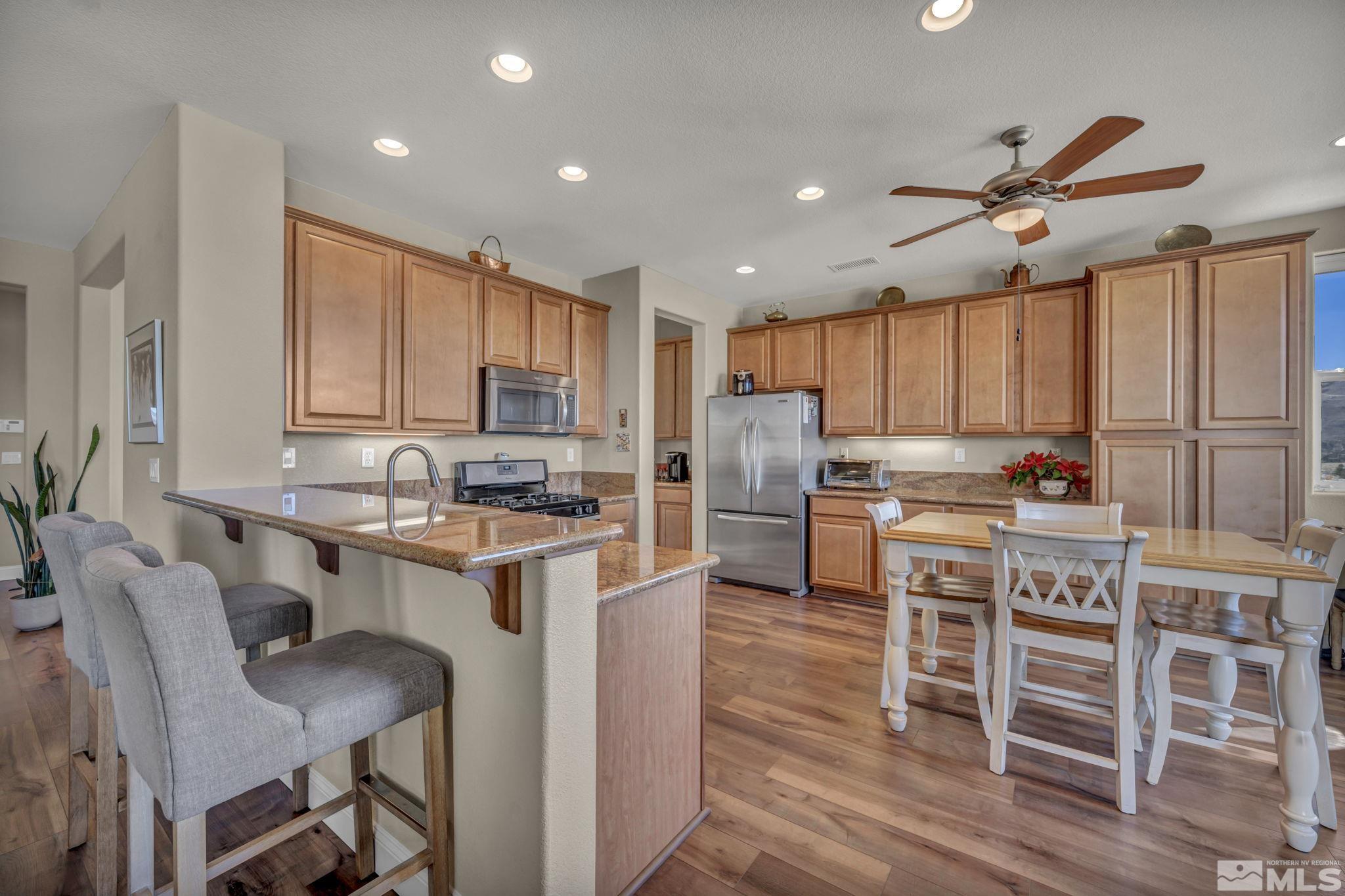 1479 Snow Summit Drive Reno, NV 89523 - Photo 10 of 40 a kitchen with refrigerator cabinets dining table and chairs