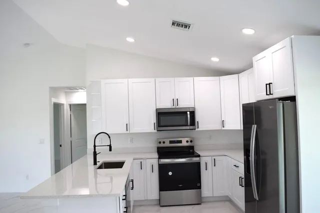 a kitchen with stainless steel appliances a refrigerator sink microwave and cabinets