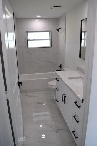 a bathroom with a tub sink and mirror