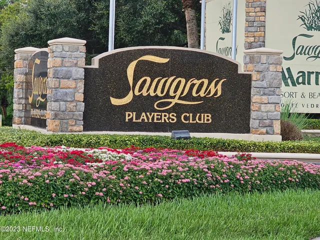 a sign that is sitting in front of flowers