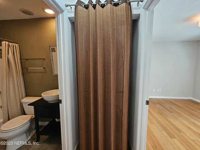 a bathroom with a sink a toilet a mirror and shower