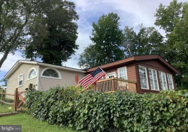 a front view of a house with a yard and trees