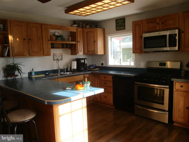 a kitchen with stainless steel appliances granite countertop a sink a stove and microwave