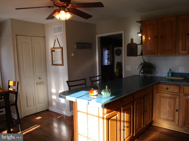 a kitchen with stainless steel appliances granite countertop a refrigerator a sink dishwasher and wooden cabinets with wooden floor