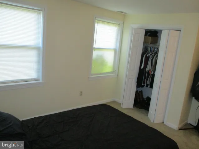 a view of hallway with window and wooden floor