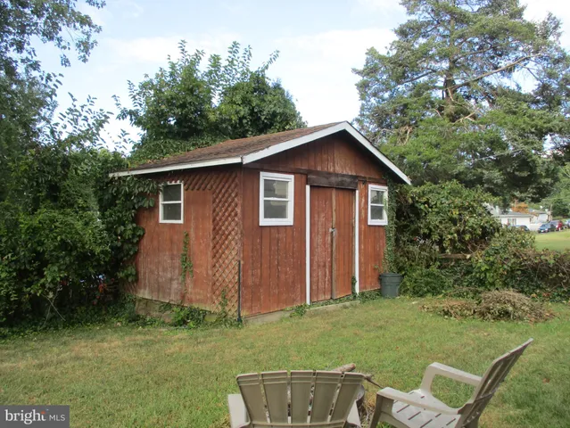 a view of a backyard with barn and large trees