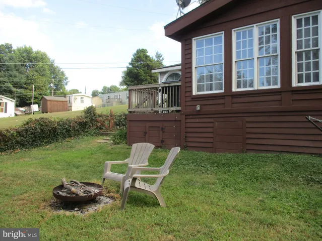 a view of a chair and table in backyard of the house